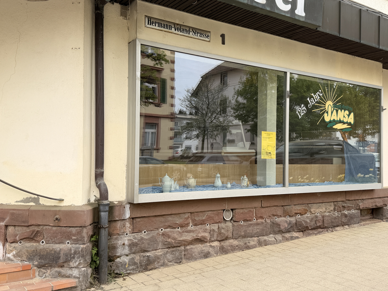 Ein Schaufenster mit der Aufschrift "135 Jahre Jansa" zeigt hinter Glas auf einem Regal eine Teekanne mit Zucker- und Milchgefäß.
