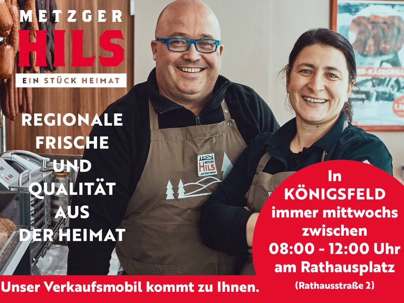 Ein lächelndes Paar steht in einer Metzgerei vor einer Fleischtheke, umgeben von Informationen über regionale Produkte und Verkaufszeiten in Königsfeld.